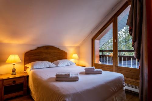 夏蒙尼-勃朗峰巴拉贡撒沃酒店的一间卧室配有一张大床和毛巾