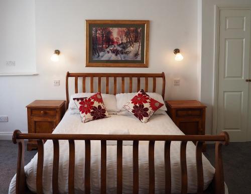 滕比诺曼底旅馆的一间卧室配有一张带两个枕头的床