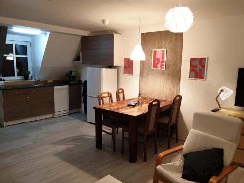 沃梅尔斯泰德großes offenes Loft oder kleine gemütliche Wohnung mit Balkon的厨房以及带木桌和椅子的用餐室。