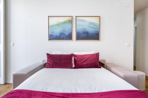 里斯本WHome | Alcântara Premium Studio的卧室配有白色床和紫色枕头