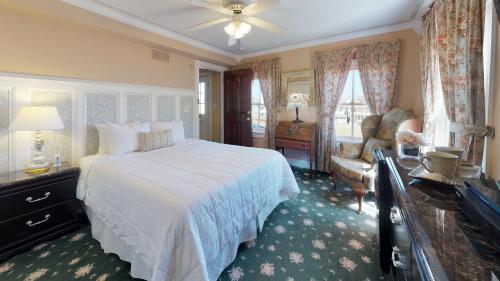 欧申格罗夫海洋广场住宿加早餐旅馆的卧室配有一张白色大床和一把椅子