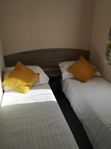 Flookburghlakeland leisure park的两张睡床彼此相邻,位于一个房间里