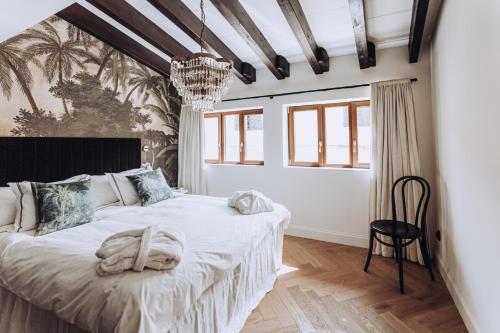 马略卡岛帕尔马Ocho Suites & Kitchen的一间卧室配有一张大床和一个吊灯。