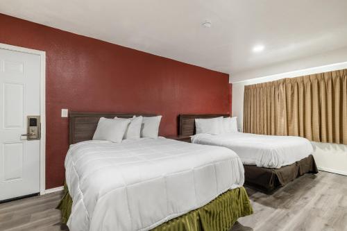 针城Econo Lodge的红色墙壁的酒店客房内的两张床