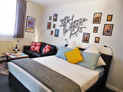 GangeltAltes Brauhaus的一间卧室配有一张带色彩缤纷枕头的床和一张沙发。