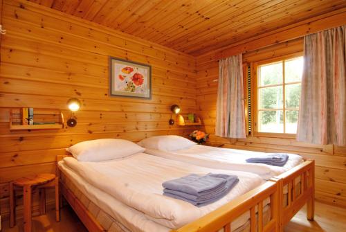 蓬卡哈尤Hapimag Ferienwohnungen Punkaharju的小木屋内一间卧室,配有一张床