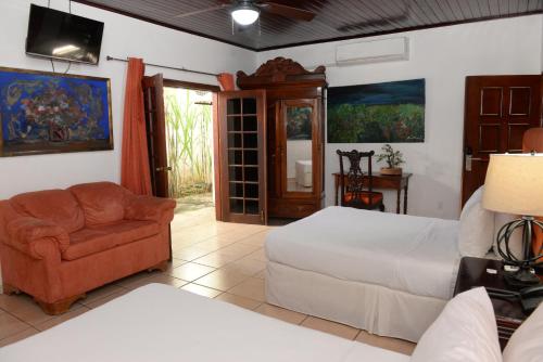马那瓜拉波萨达德尔阿康热尔住宿加早餐旅馆的一间卧室配有一张床、一张沙发和一把椅子