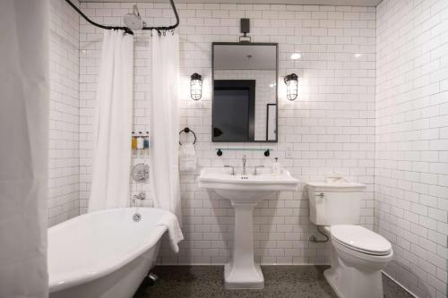 RanierCantilever Hotel, Trademark Collection by Wyndham的白色的浴室设有水槽、卫生间和浴缸。
