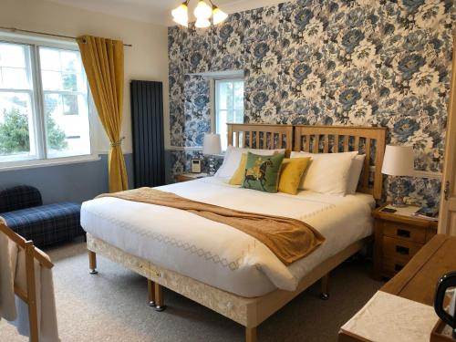 布莱尔阿瑟尔Dalgreine Guest House的一间卧室配有一张蓝色和白色壁纸的大床