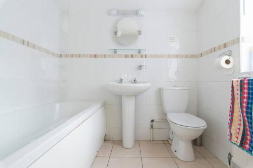 霍尔特Jims Cottage的白色的浴室设有水槽和卫生间。