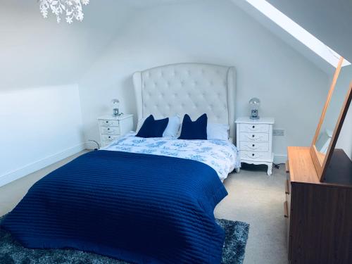 埃普沃思Holiday Home Epworth的一间卧室配有一张大床,配有蓝色的床单和蓝色的枕头。