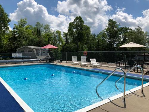 哈里伯顿湖景汽车旅馆的度假村的游泳池,配有椅子和遮阳伞