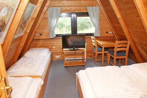 达普Zeltdachhaus _ 2 x TV _ ruhige Lag的客房设有两张床、一张桌子和电视。