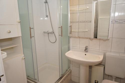 达普Zeltdachhaus _ 2 x TV _ ruhige Lag的白色的浴室设有水槽和淋浴。