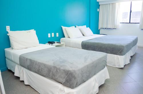 萨尔瓦多巴伊亚索尔玛酒店的蓝色墙壁客房的两张床