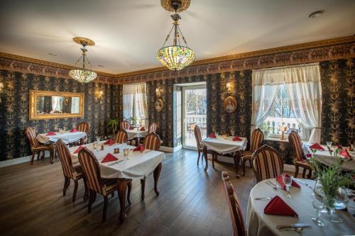 隆代克-兹德鲁伊Rezydencja Grawert Boutique & Spa的一间设有桌椅的餐厅,位于带壁纸的房间