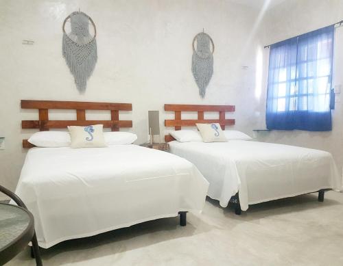 奥尔沃克斯岛Casa Chujuk by Spirit Group的一间卧室设有两张带白色床单的床和窗户。