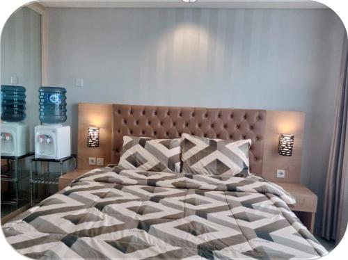 茂物Channel Stay @ Bogor Icon Apartment的一间卧室配有一张大床和大床头板