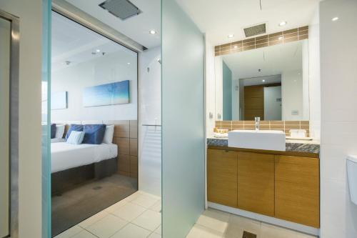 汤斯维尔城市度假酒店 - 赌场的一间带水槽、床和镜子的浴室