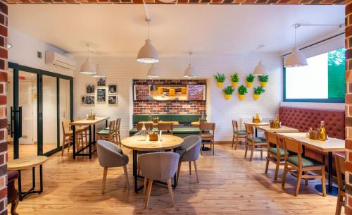 新德里bloomrooms @ Janpath的餐厅设有木桌和椅子,拥有砖墙