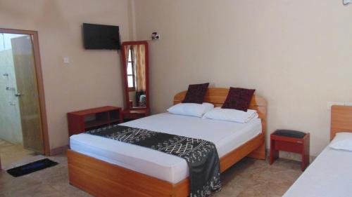 亭可马里阿拉斯花园酒店的一间卧室配有两张床和电视。