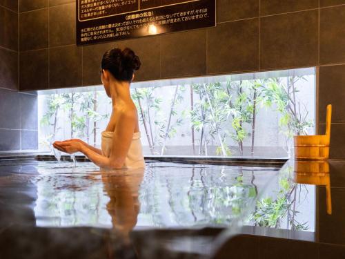 东京品川新马场超级酒店的坐在浴缸里,看着窗外的女人
