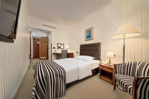萨格勒布杜布罗弗尼克酒店的酒店客房,配有一张床和两把椅子