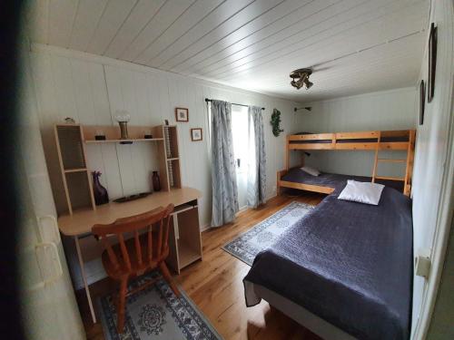 HerrängHaga gård och Stall的一间卧室配有一张床、一张桌子和一张桌子