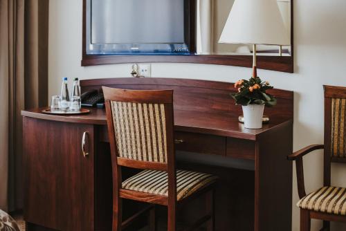 波兹南科瑞尔酒店的一张桌子,位于酒店的房间,配有一盏灯和一把椅子