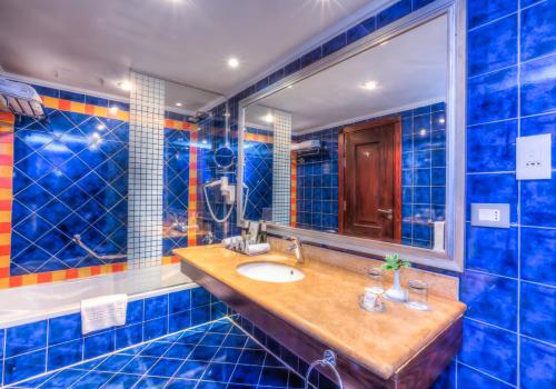 马特鲁港波尔图玛特鲁海滩度假酒店的蓝色瓷砖浴室设有水槽和镜子