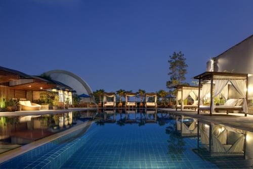 万隆阿里亚万隆酒店的一座带椅子的游泳池以及一座建筑