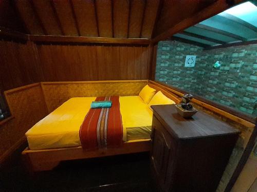 特特巴图Tetebatu Valley Bungalows的一张小床,位于带桌子的房间