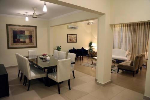 拉瓦尔品第Butterfly Guest House Phase 7 Bahria Town的用餐室以及带桌椅的起居室。