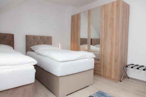 杜伊斯堡T&K Apartments near Messe Fair Trade Düsseldorf und Airport 3A的一间卧室配有两张床和镜子