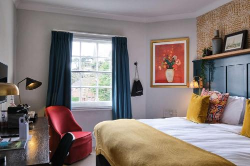 布罗姆利公牛头酒店的一间卧室配有一张床、一张书桌和一个窗户。