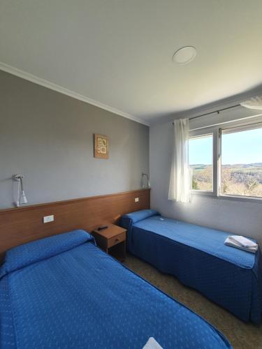 波尔托马林波尔托米诺旅馆的一间卧室设有两张床和窗户。