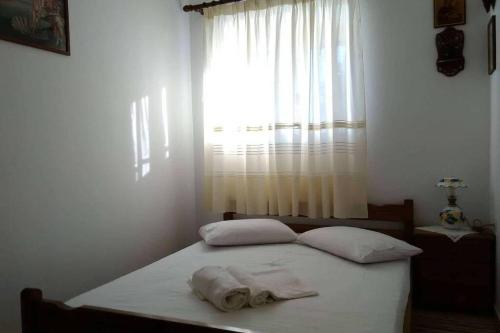 凯瑟拉Kasi's nature home的一间卧室配有带两个枕头的床和窗户
