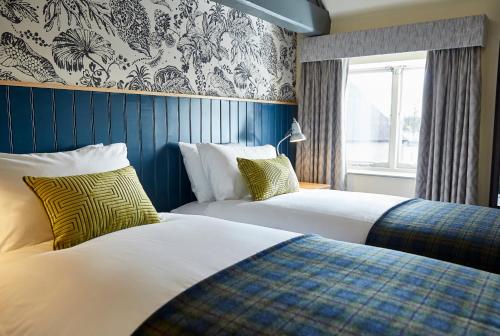 埃文河畔斯特拉特福Pen and Parchment by Greene King Inns的酒店客房设有两张床和窗户。
