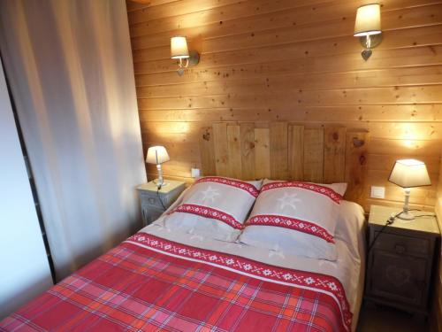 Saint-Genès-ChampespeChalet des Clarines的一间卧室配有一张带两个红色和白色枕头的床