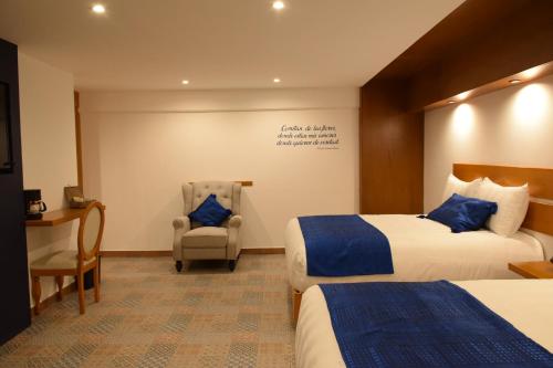 科米坦德多明格斯La Alborada的酒店客房,配有两张床和椅子