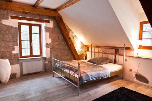施卢赫湖Herrenhaus Schluchsee的阁楼上的卧室配有金属床