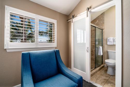 基拉戈Waterside Suites and Marina的一间带蓝色椅子和卫生间的浴室