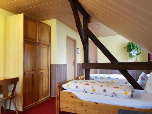 FrauenhagenPension zum Wiesengrund的一间卧室配有一张带枕头的木床