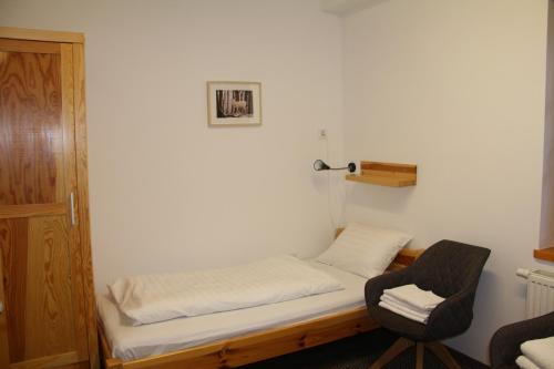 布达佩斯Rotter Lajos Turistaház的小房间设有一张床和一把椅子