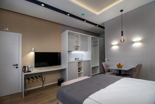 萨拉热窝Beys Palace apartments Sarajevo的一间卧室配有一张床、一台电视和一张桌子