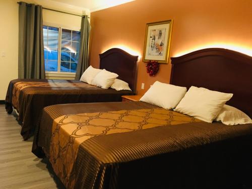 洛杉矶林肯公园汽车旅馆的酒店客房设有两张床和窗户。