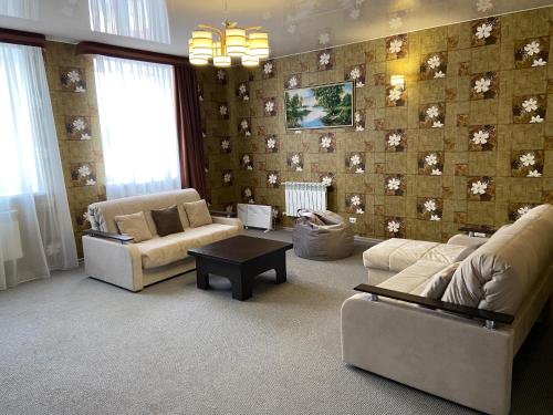 布拉戈维申斯克德鲁日巴酒店的客厅设有两张沙发和一堵鲜花墙