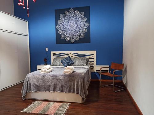 罗萨里奥BELLA CASA 110m2 - CENTRO - PATIO - PARRILLA的一间卧室配有一张蓝色墙壁的床