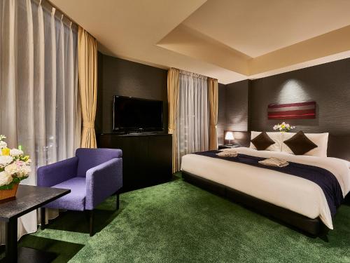 东京浅草雷门休雷克盖特酒店的一间卧室配有一张大床和一张紫色椅子