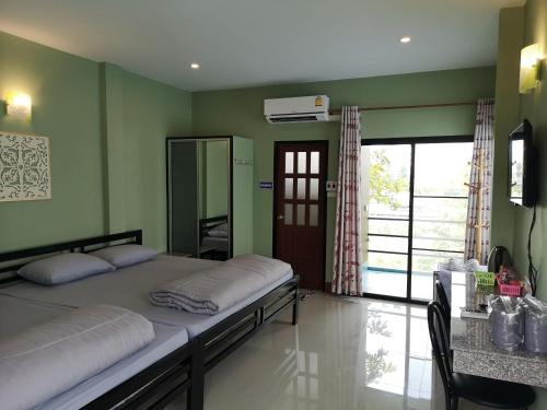 Ban Nong Nakโรงแรมห้วยทราย Huaisai Hotel的一间卧室设有两张床、镜子和窗户